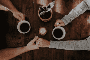 dos manos y dos tazas de café