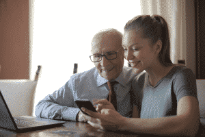un anciano con una chica mirando el movil
